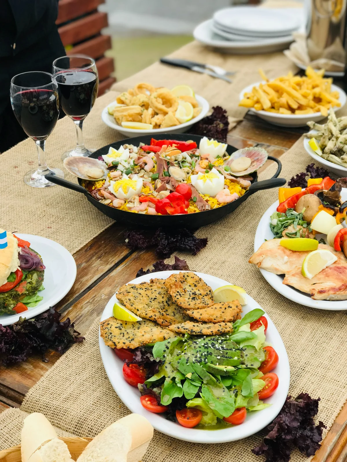 Mesa servida con platos y ensaladas en el restaurante Open Playa